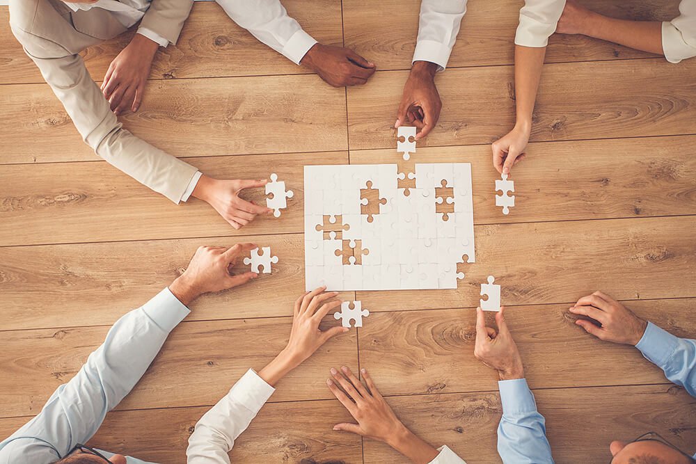 Colaboradores montam quebra-cabeça representando a colaboração no PCMSO
